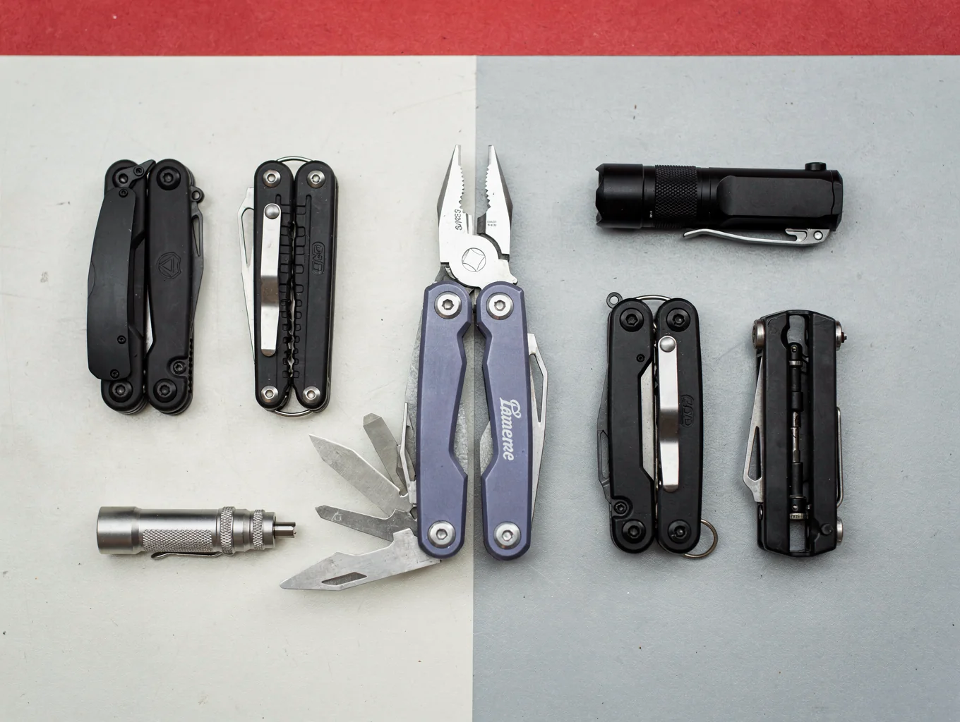 A stainless steel multi-tool with pliers deployed and a compact pocket flashlight sitting inside an open waxed canvas pouch.