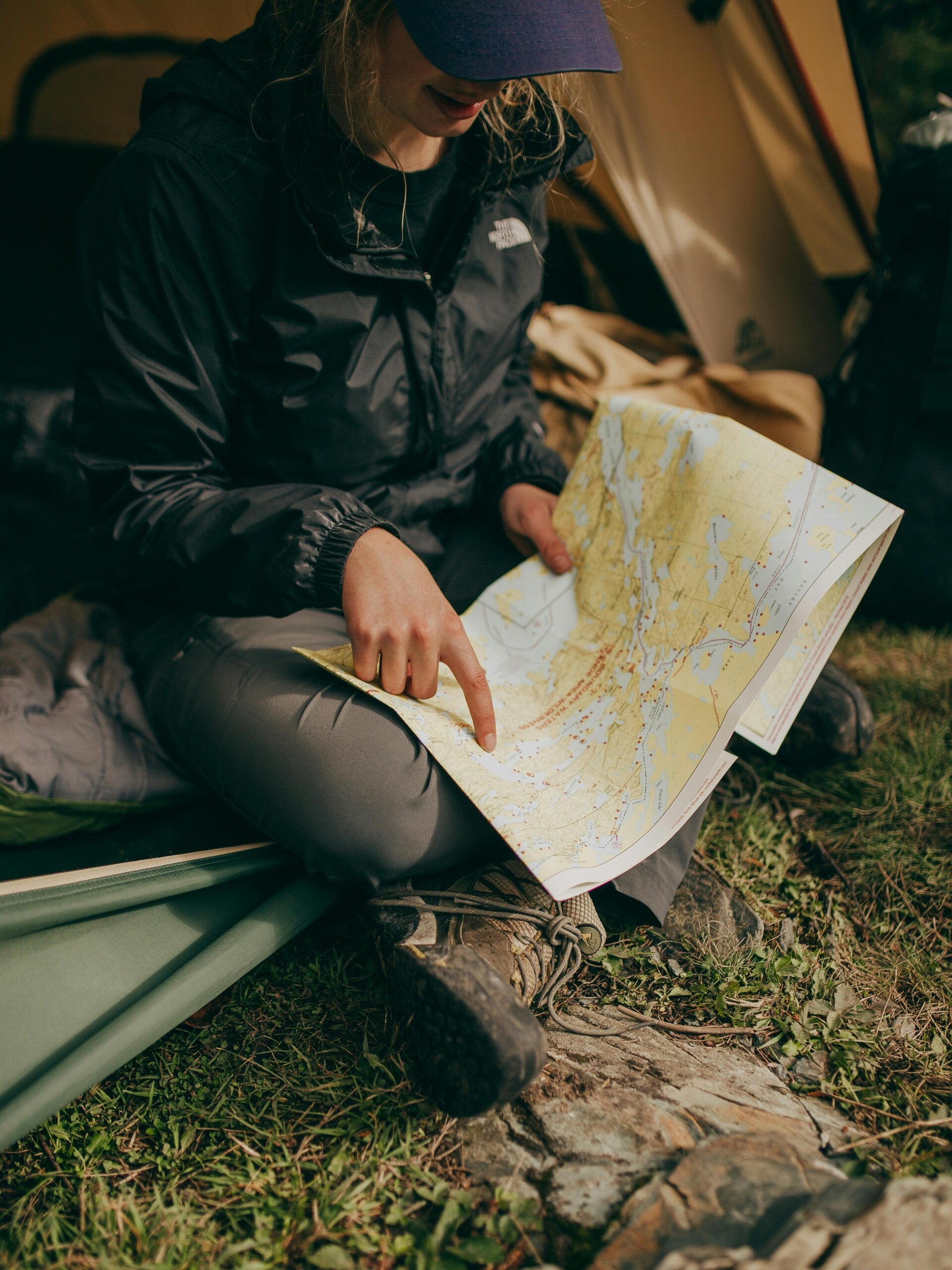 An outdoor explorer reading a paper map in the wilderness